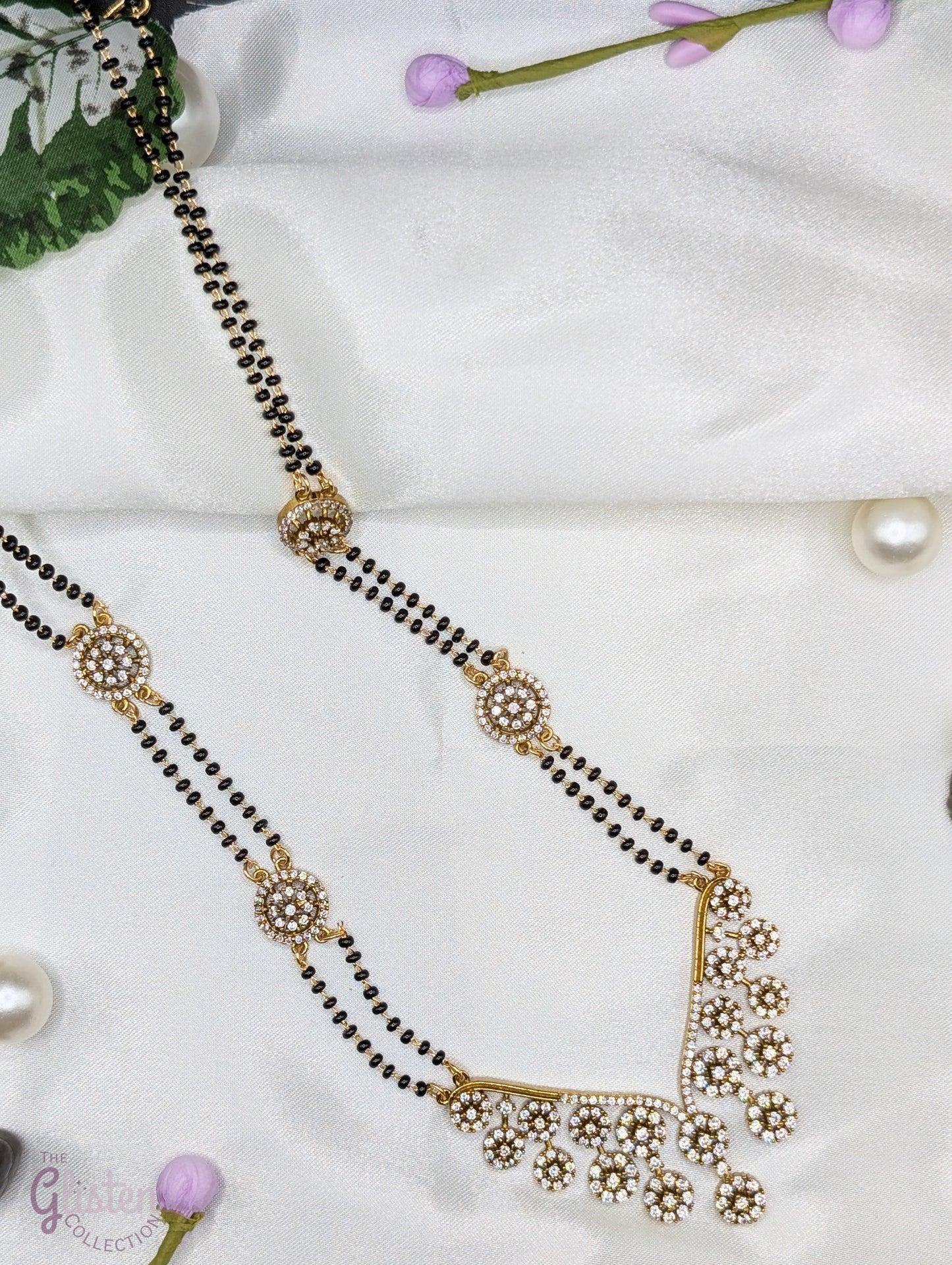 Long mangalsutra with black beads, V-shaped stone pendant, and round stone accents — ideal for modern traditional wear and daily elegance.