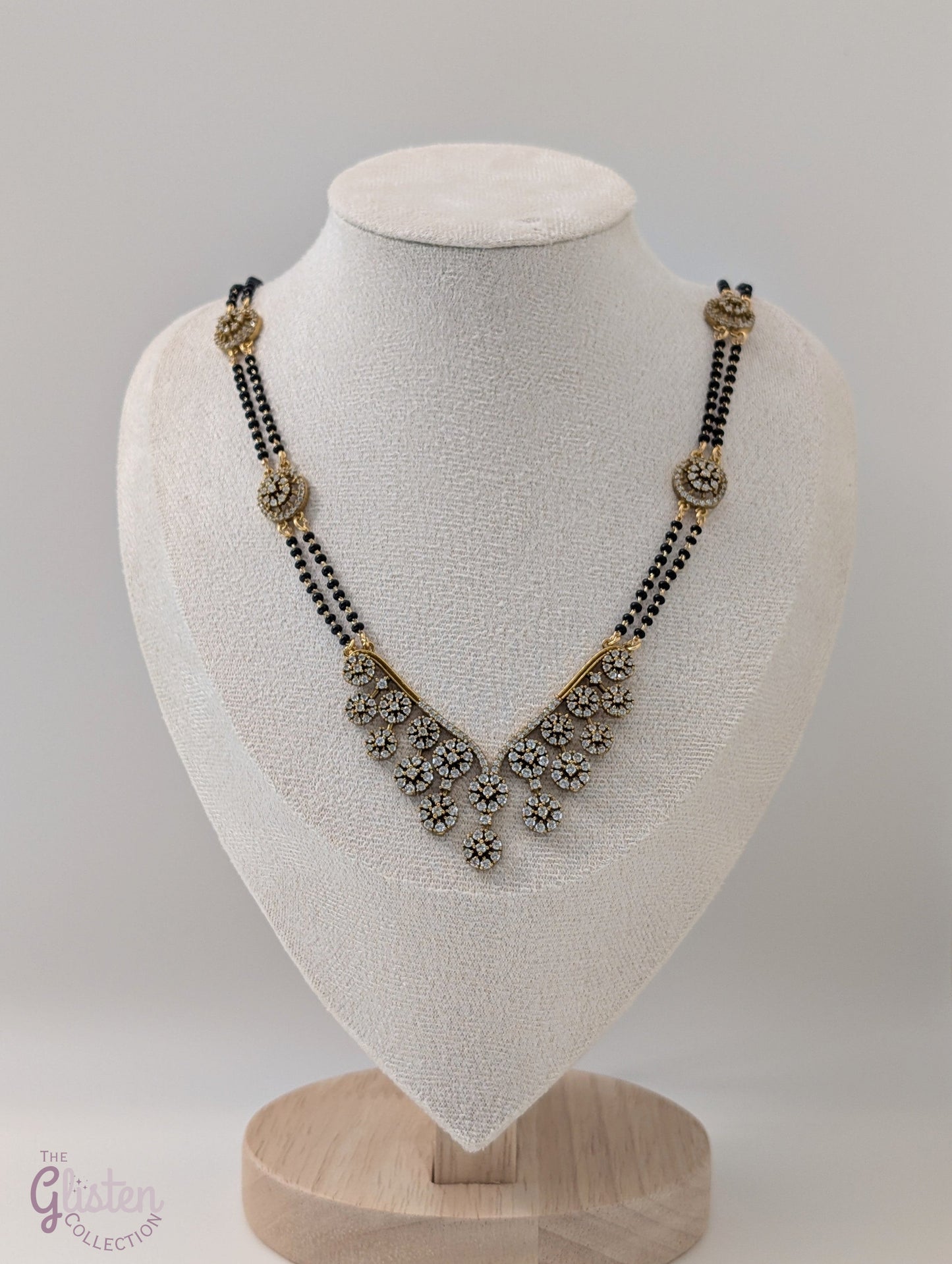 Long mangalsutra with black beads, V-shaped stone pendant, and round stone accents — ideal for modern traditional wear and daily elegance.