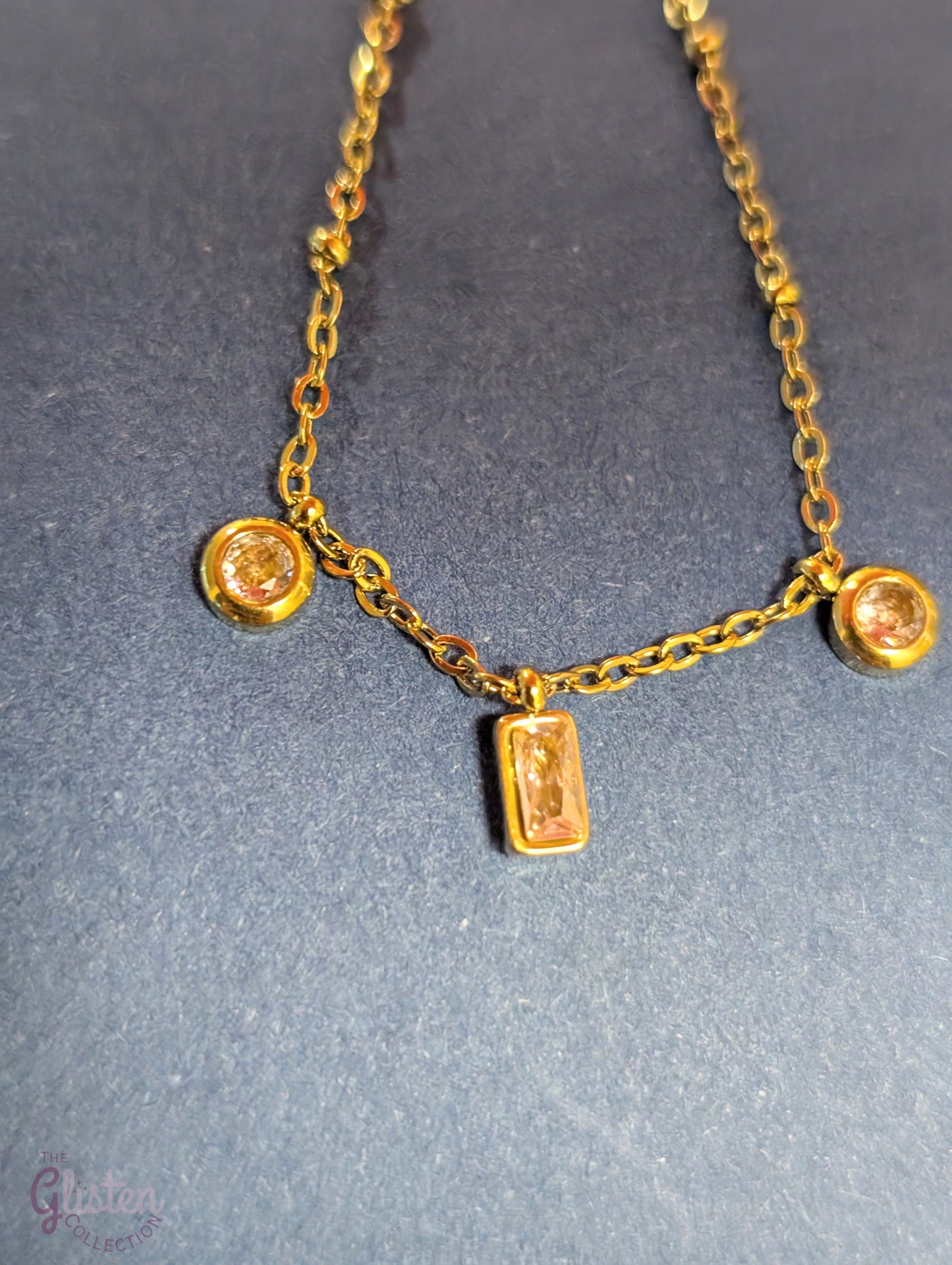 Pink charm geometric bracelet with circular and rectangular charms in pink, complemented by gold-plated links for a stylish and minimalist look.