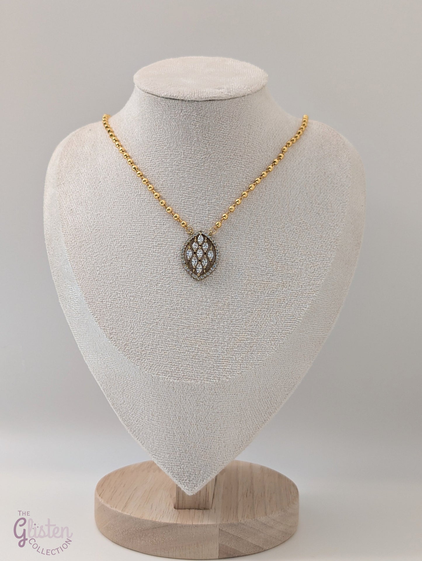 Gold-tone short necklace with gold balls and leaf-shaped pendant adorned with stones — simple, elegant daily wear jewellery.