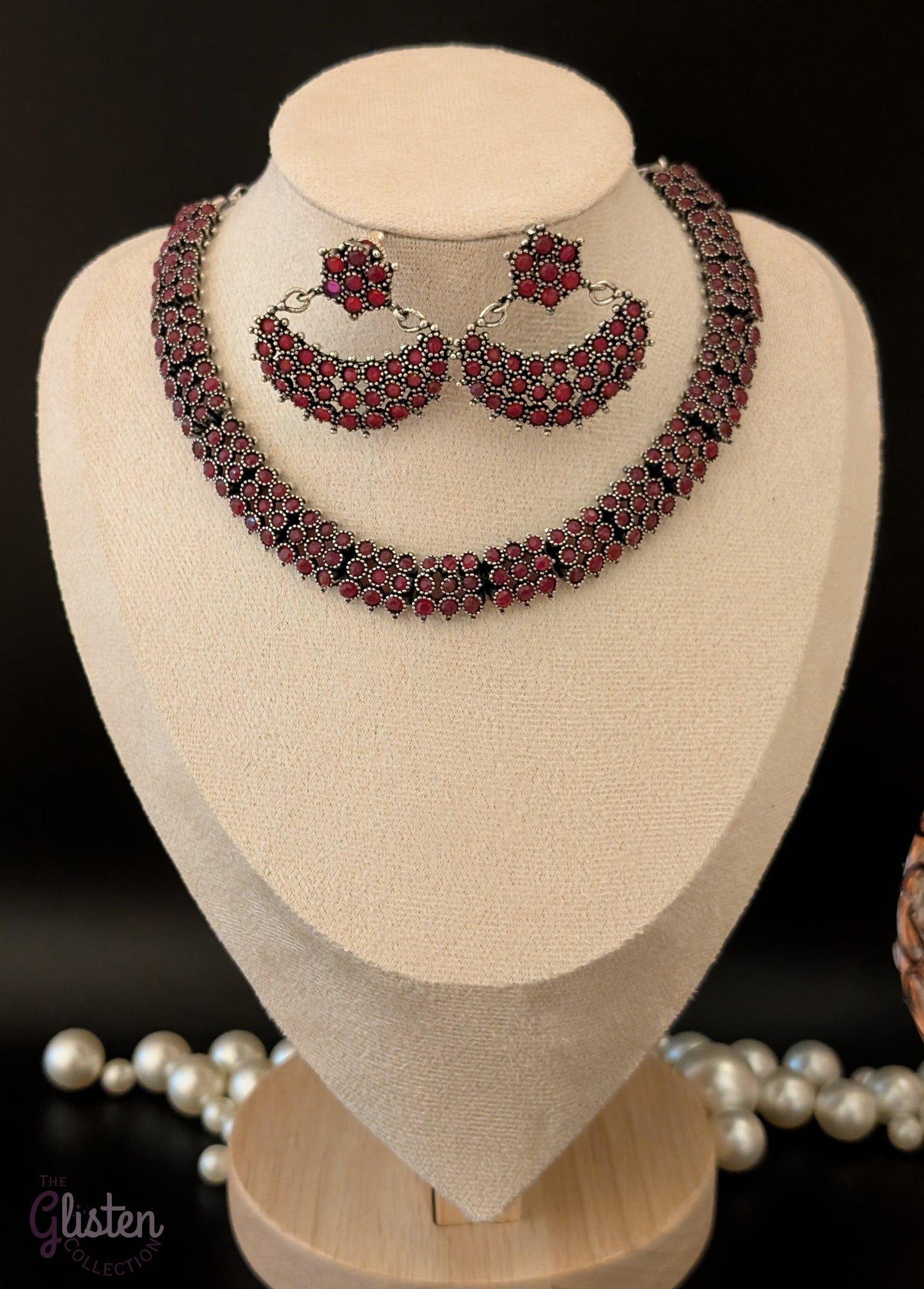 Oxidized silver necklace set with red stones and black finish, paired with crescent-shaped floral earrings — ideal for festive occasions and traditional Indian outfits.
