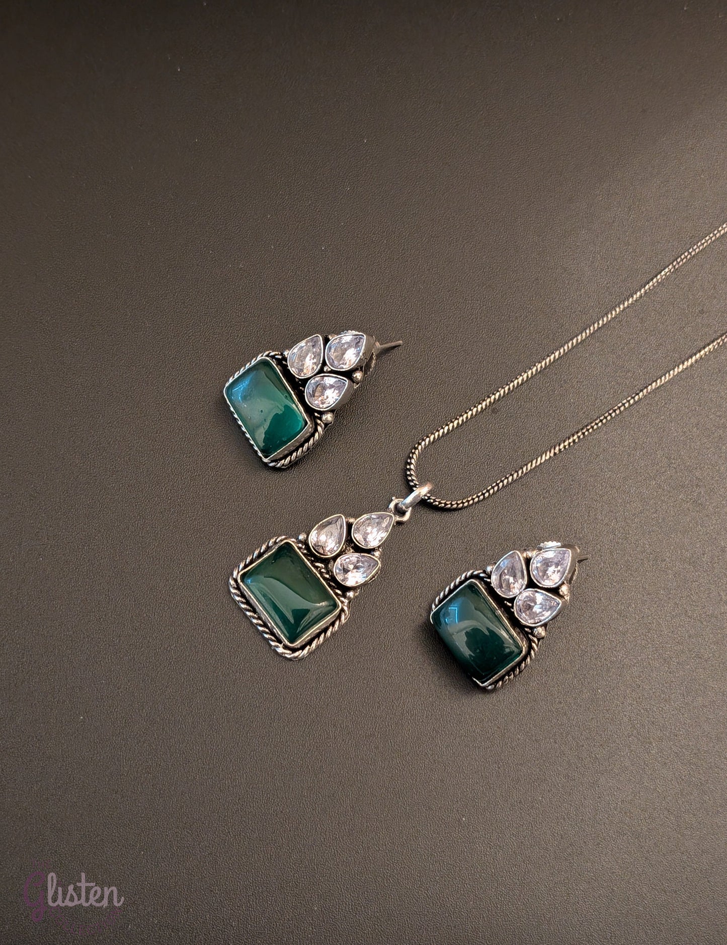 Oxidized silver pendant set with rectangular green stones, twisted rope frame, and American Diamonds — perfect for festive, ethnic, or everyday looks.