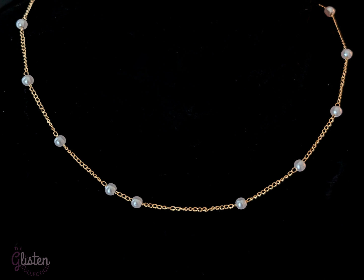 Pearl Ball Chain features a beautiful gold-tone chain adorned with small pearl ball accents.