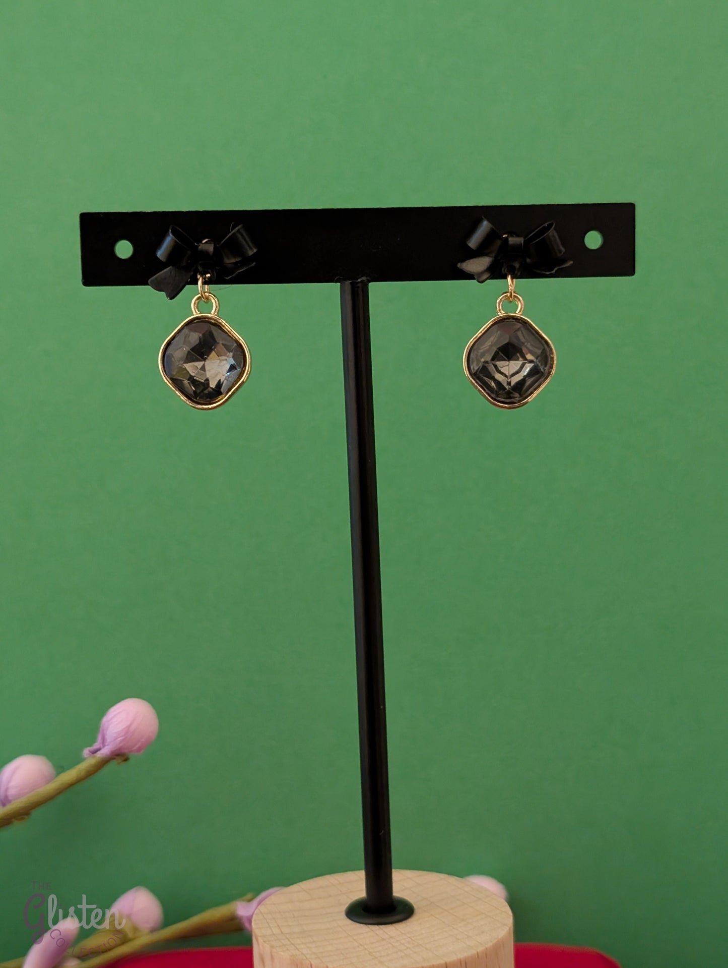 Black bow knot earrings with shiny black stone and pearl drop. Elegant and minimalist design.