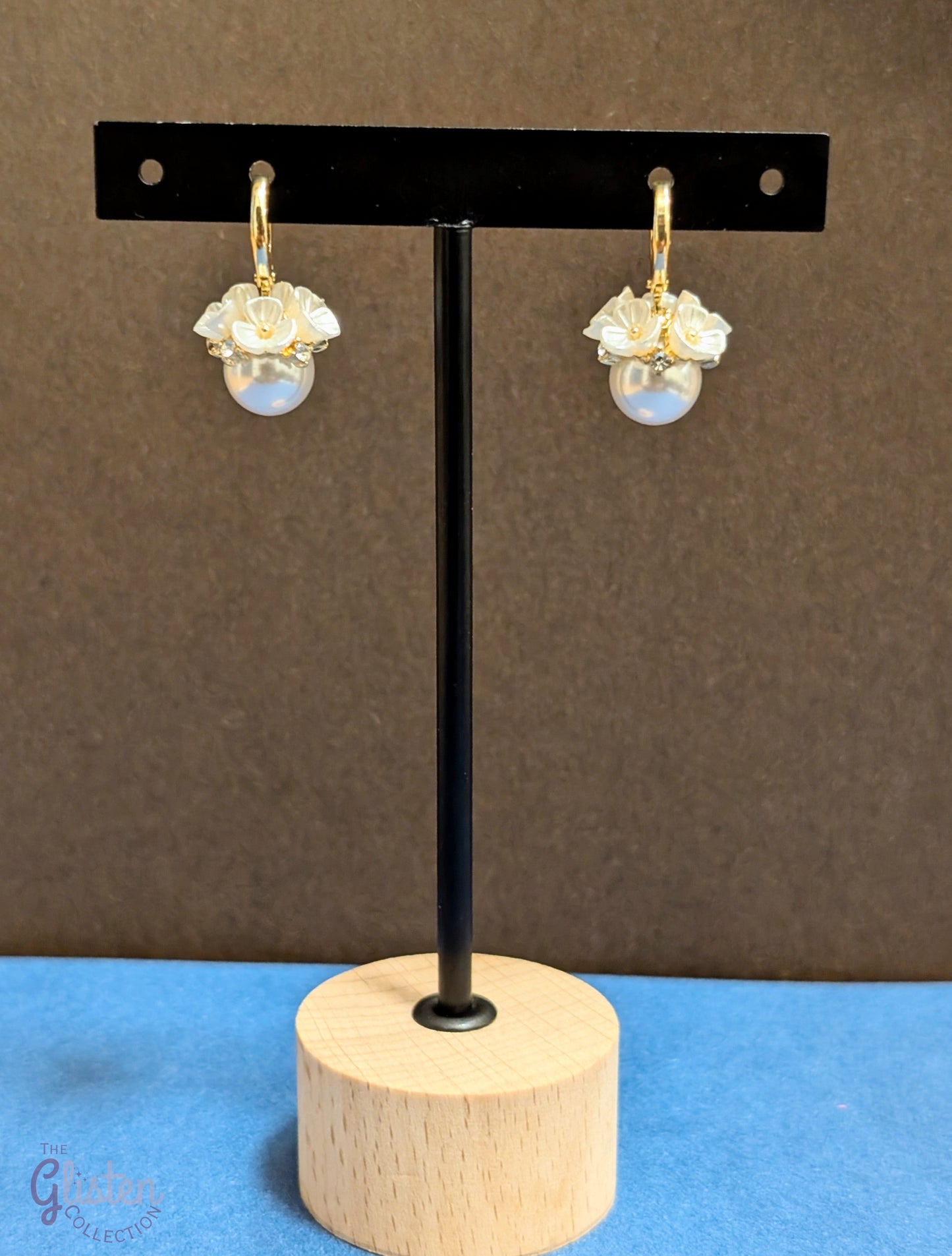 Flower-shaped drop earrings with rhinestone detailing and pearl dangle, perfect for elegant styling and special occasions.
