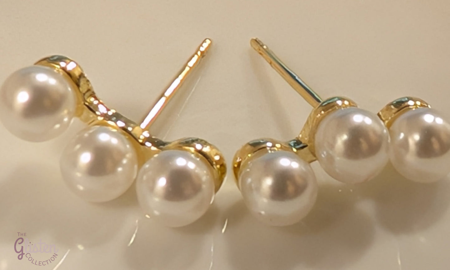 Round gold-plated pearl stud earrings with a minimalist design for everyday and office wear.