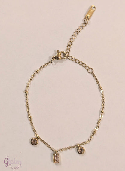 Pink charm geometric bracelet with circular and rectangular charms in pink, complemented by gold-plated links for a stylish and minimalist look.