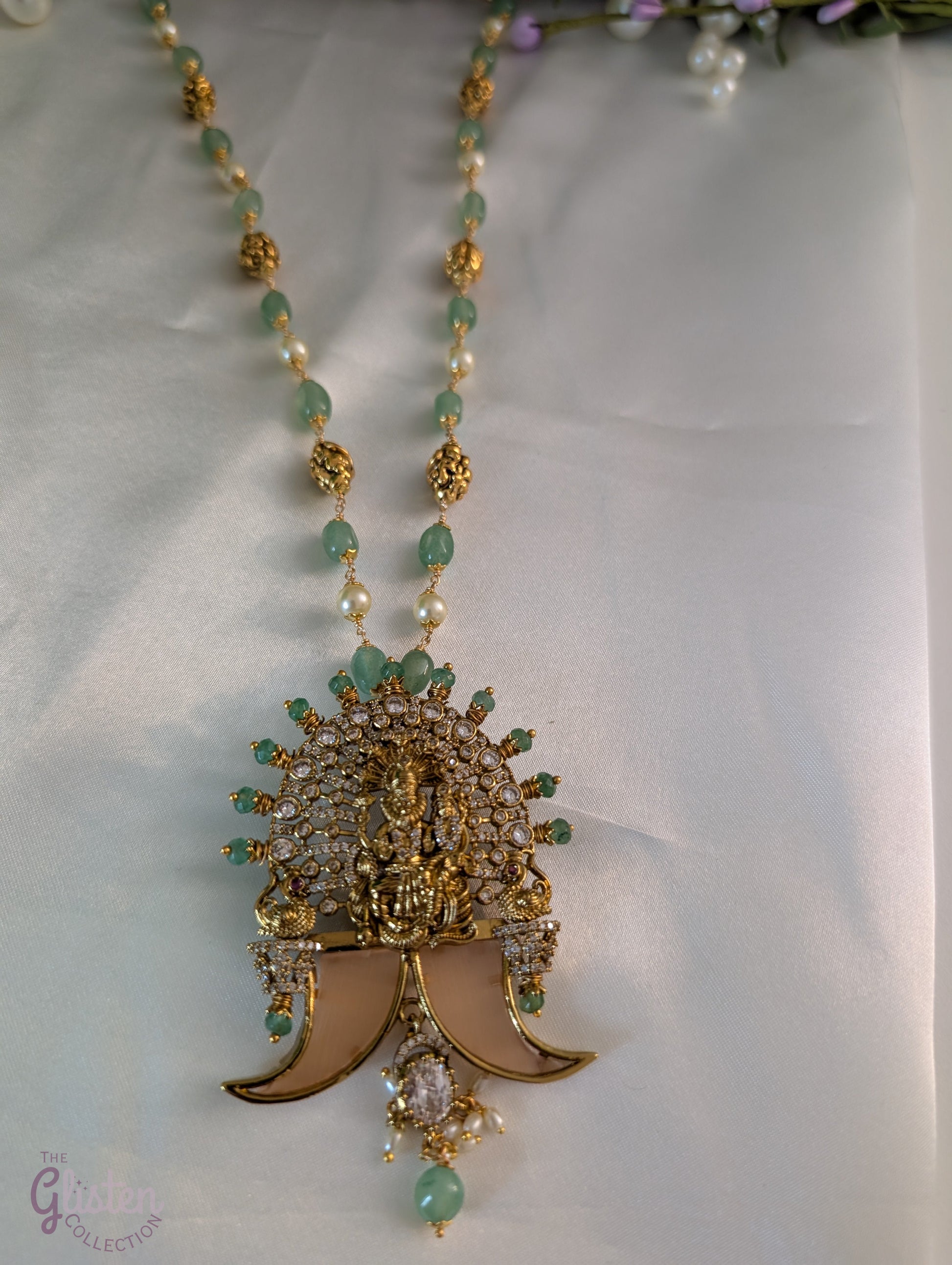 Long green beaded necklace with tiger nail–style pendant and white pearls — statement traditional jewellery ideal for lehengas, sarees, and festive occasions.