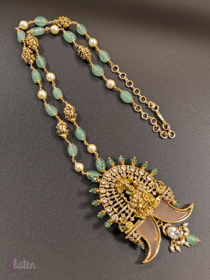 Long green beaded necklace with tiger nail–style pendant and white pearls — statement traditional jewellery ideal for lehengas, sarees, and festive occasions.