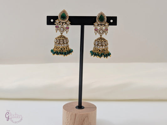 Emerald Flow Jhumkas with green stones, delicate accents, and green bead dangles — perfect for simple yet festive looks at parties and special occasions.