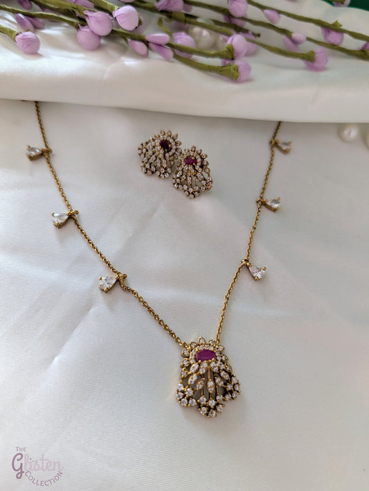 Gold-toned necklace and earrings set with red stone and CZ crystals, perfect for special occasions and everyday elegance, featuring delicate side stones and fine chain.