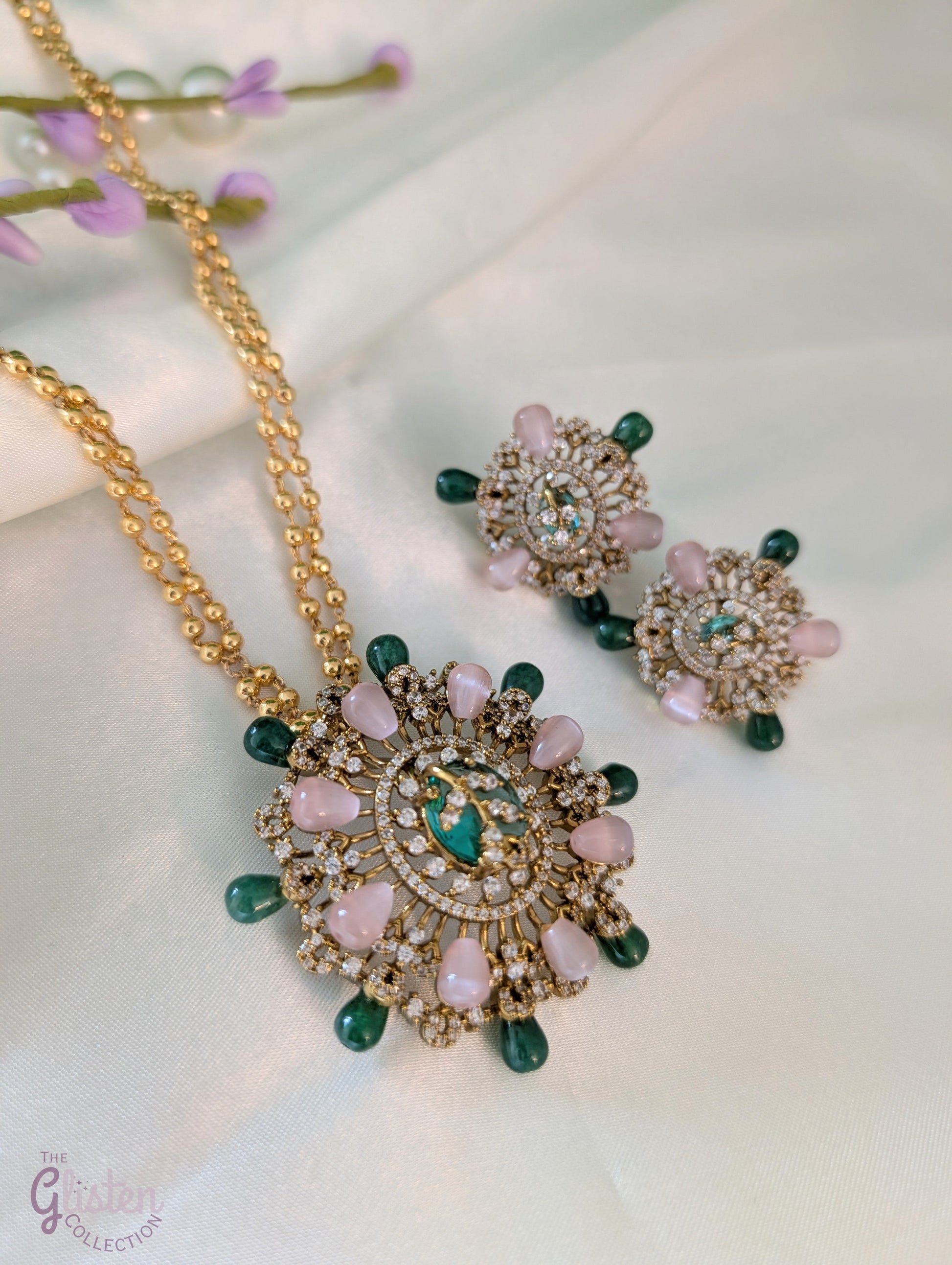 Gold-tone double-chain necklace with floral pendant featuring pink, green, and CZ stones, ideal for special occasions or enhancing simple outfits.