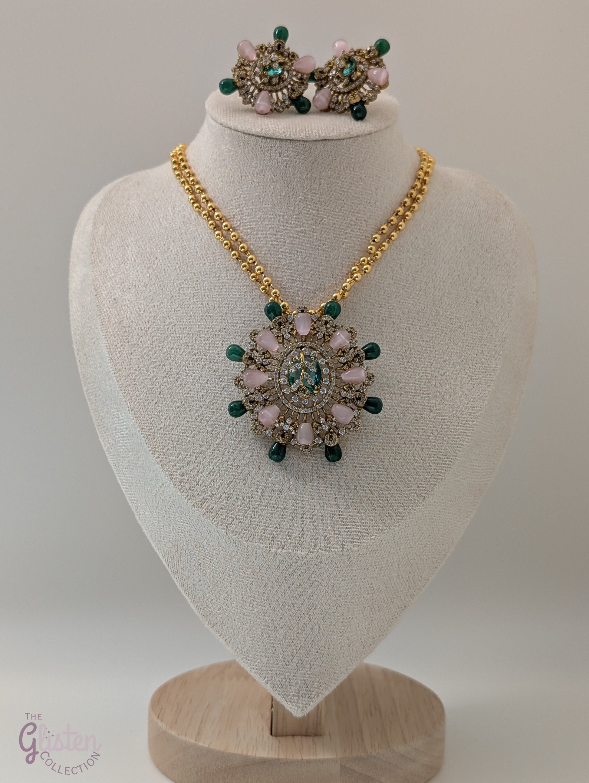 Gold-tone double-chain necklace with floral pendant featuring pink, green, and CZ stones, ideal for special occasions or enhancing simple outfits.