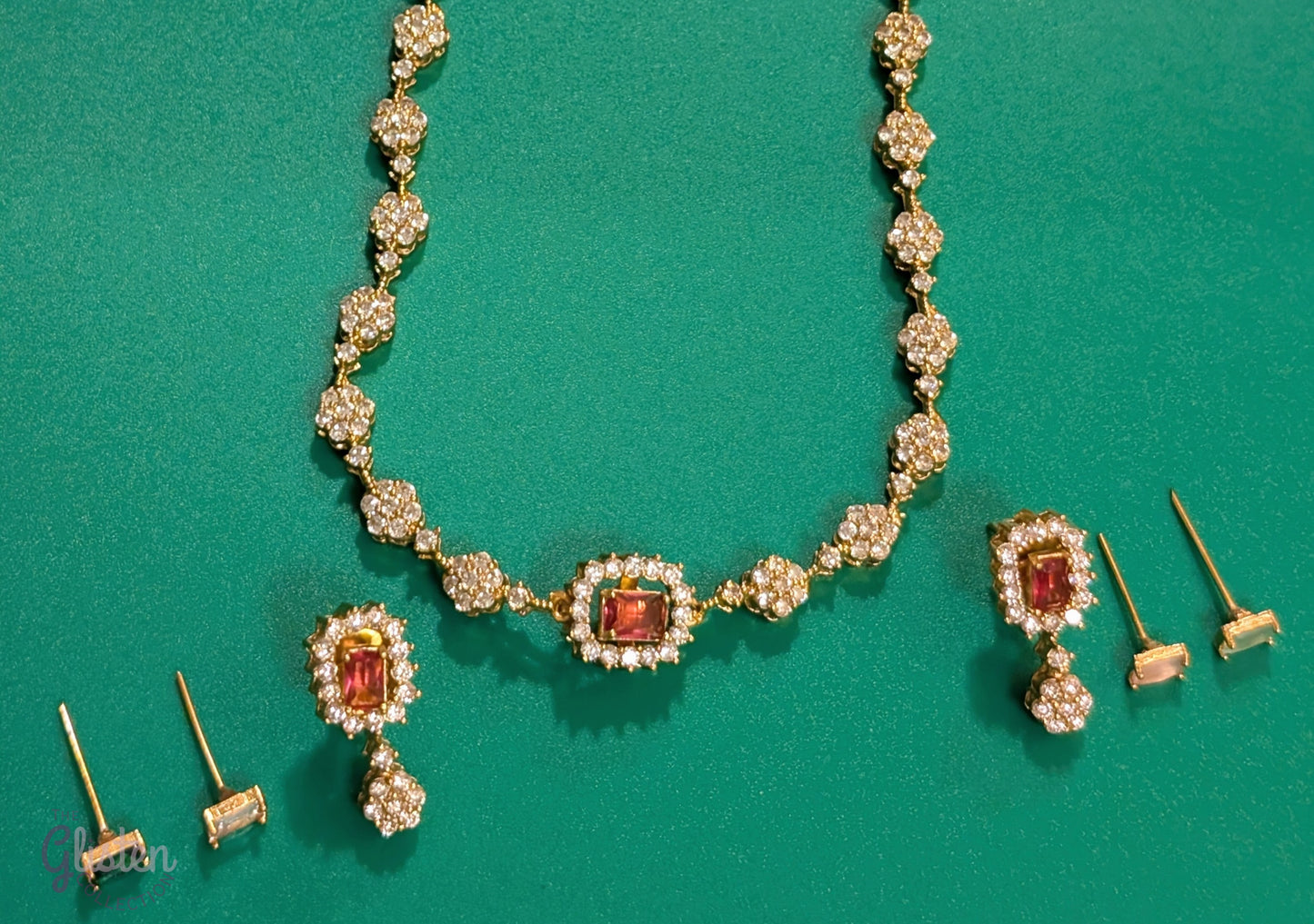 Matte gold-plated American Diamond necklace set with floral motifs and four interchangeable AD stones, ideal for formal and festive occasions.