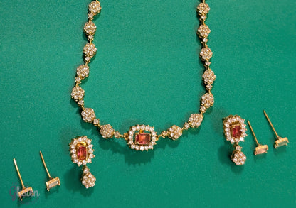 Matte gold-plated American Diamond necklace set with floral motifs and four interchangeable AD stones, ideal for formal and festive occasions.