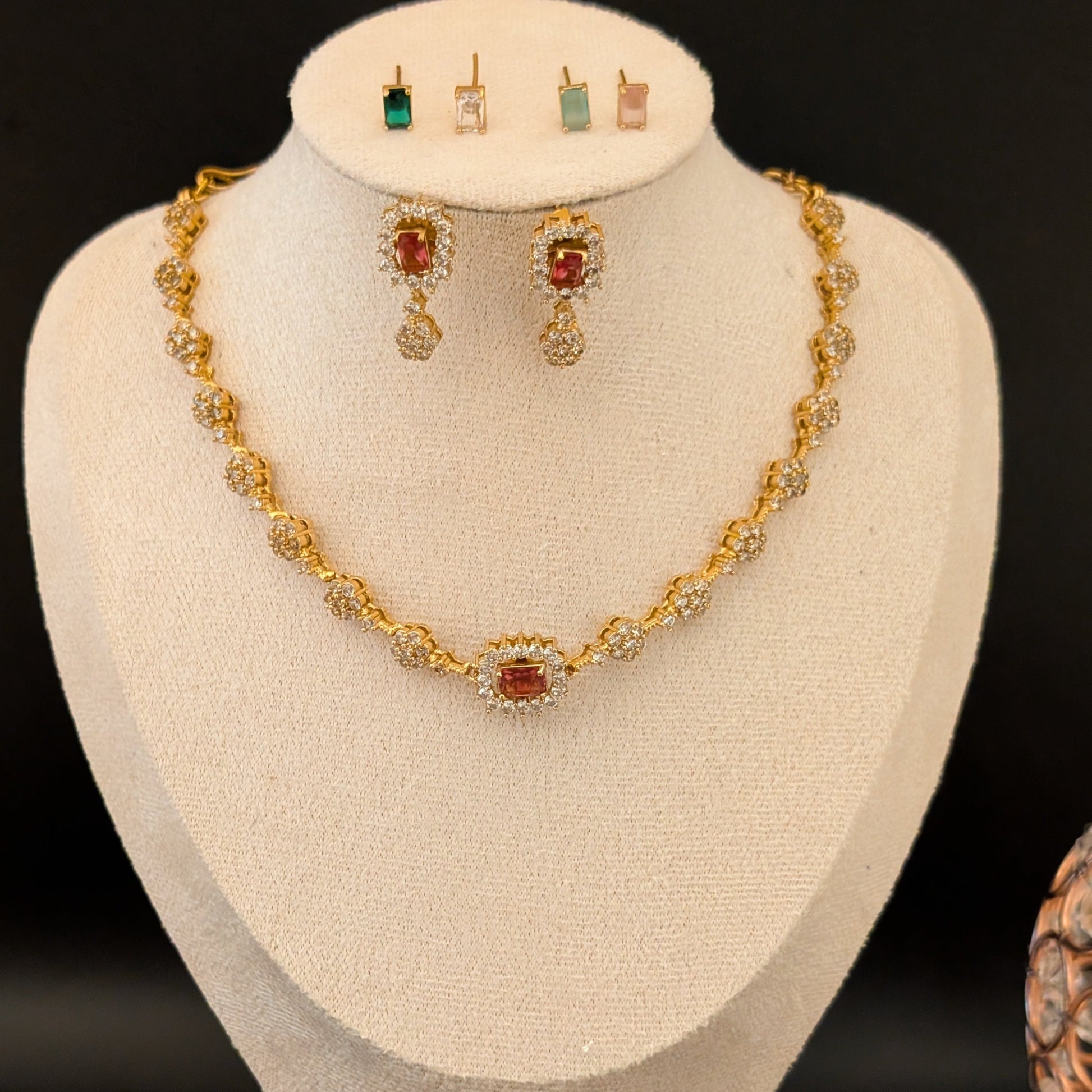 Matte gold-plated American Diamond necklace set with floral motifs and four interchangeable AD stones, ideal for formal and festive occasions.