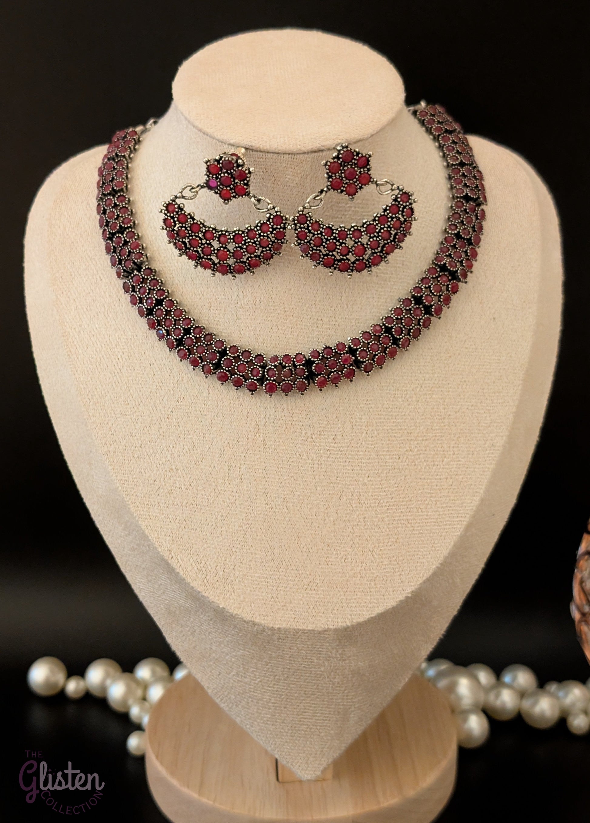 Oxidized silver necklace set with red stones and black finish, paired with crescent-shaped floral earrings — ideal for festive occasions and traditional Indian outfits.