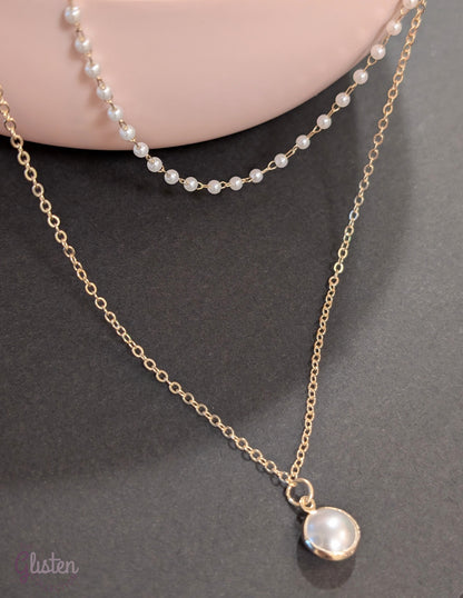 Layered silver chain necklace with pearl accents and a plain strand, ideal for everyday and office wear.