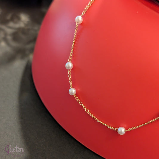 Pearl Ball Chain features a beautiful gold-tone chain adorned with small pearl ball accents.