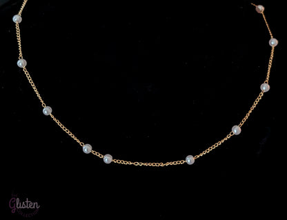 Pearl Ball Chain features a beautiful gold-tone chain adorned with small pearl ball accents.