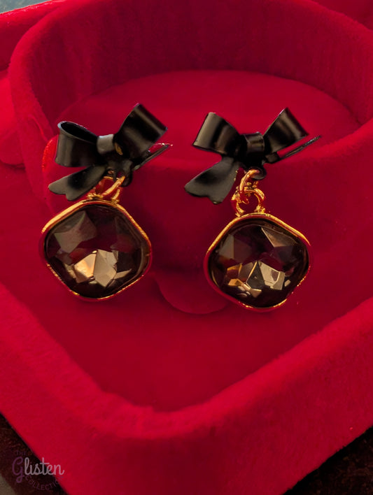 Black bow knot earrings with shiny black stone and pearl drop. Elegant and minimalist design.