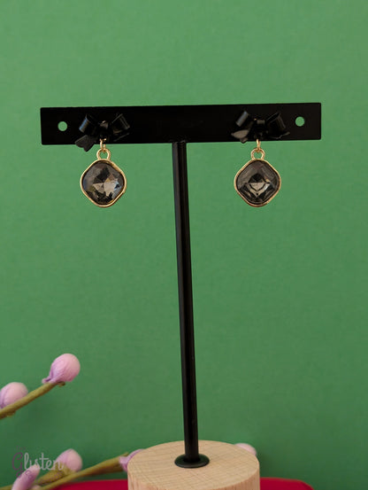 Black bow knot earrings with shiny black stone and pearl drop. Elegant and minimalist design.