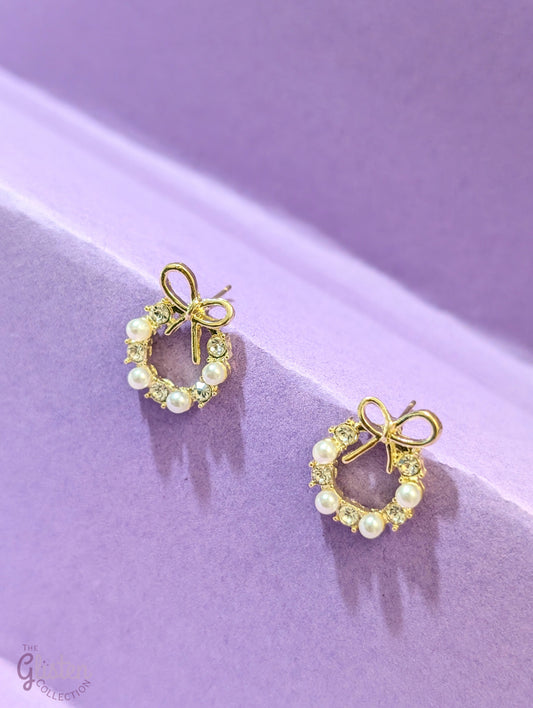 Elegant bow stud earrings with alternating pearl and zircon stones, featuring a bow on top for added charm.