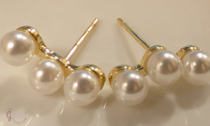 Round gold-plated pearl stud earrings with a minimalist design for everyday and office wear.
