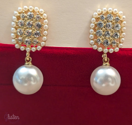 Geometric pearl drop earrings with oval-shaped tops, imitation pearls, and artificial crystals.