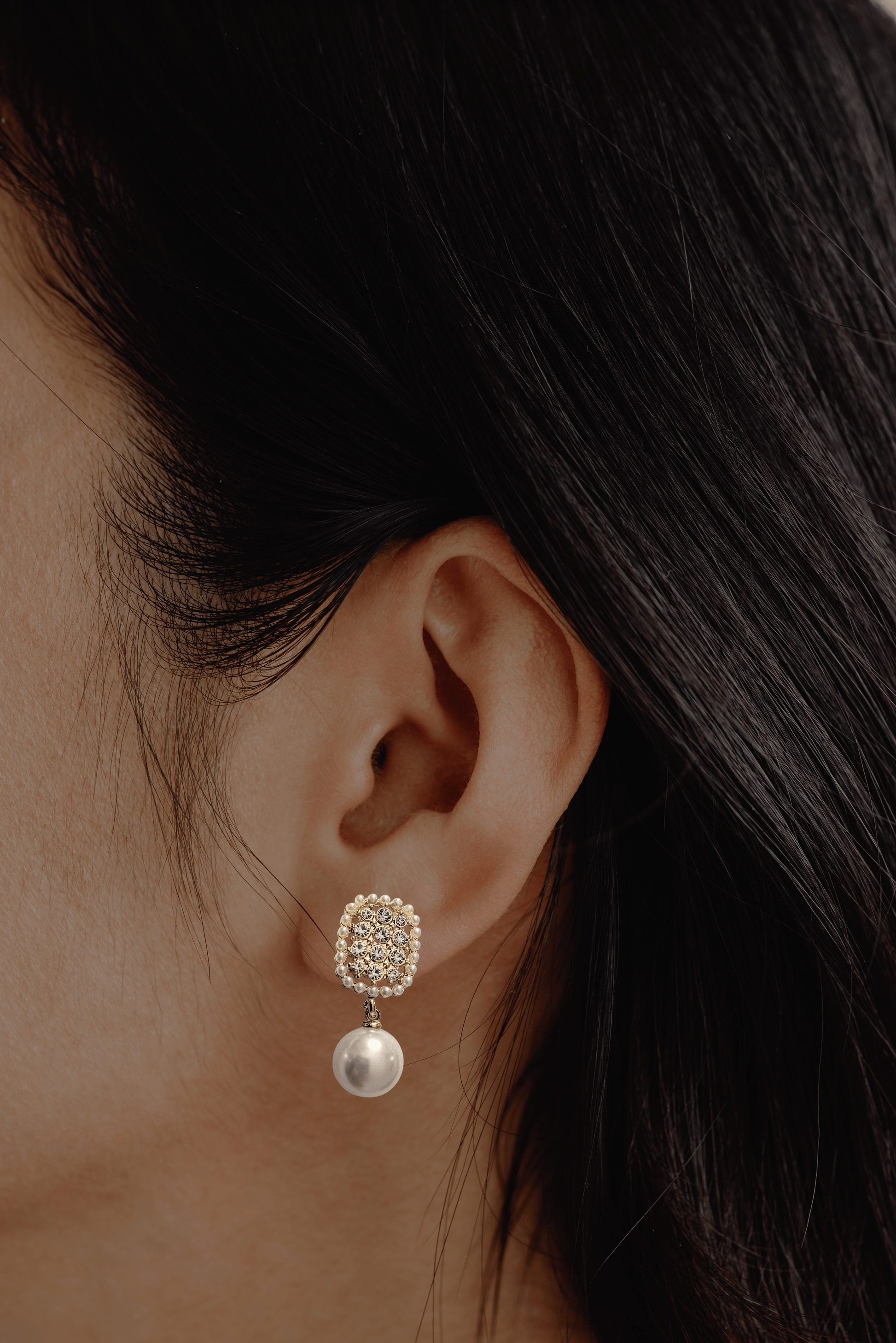 Geometric pearl drop earrings with oval-shaped tops, imitation pearls, and artificial crystals.