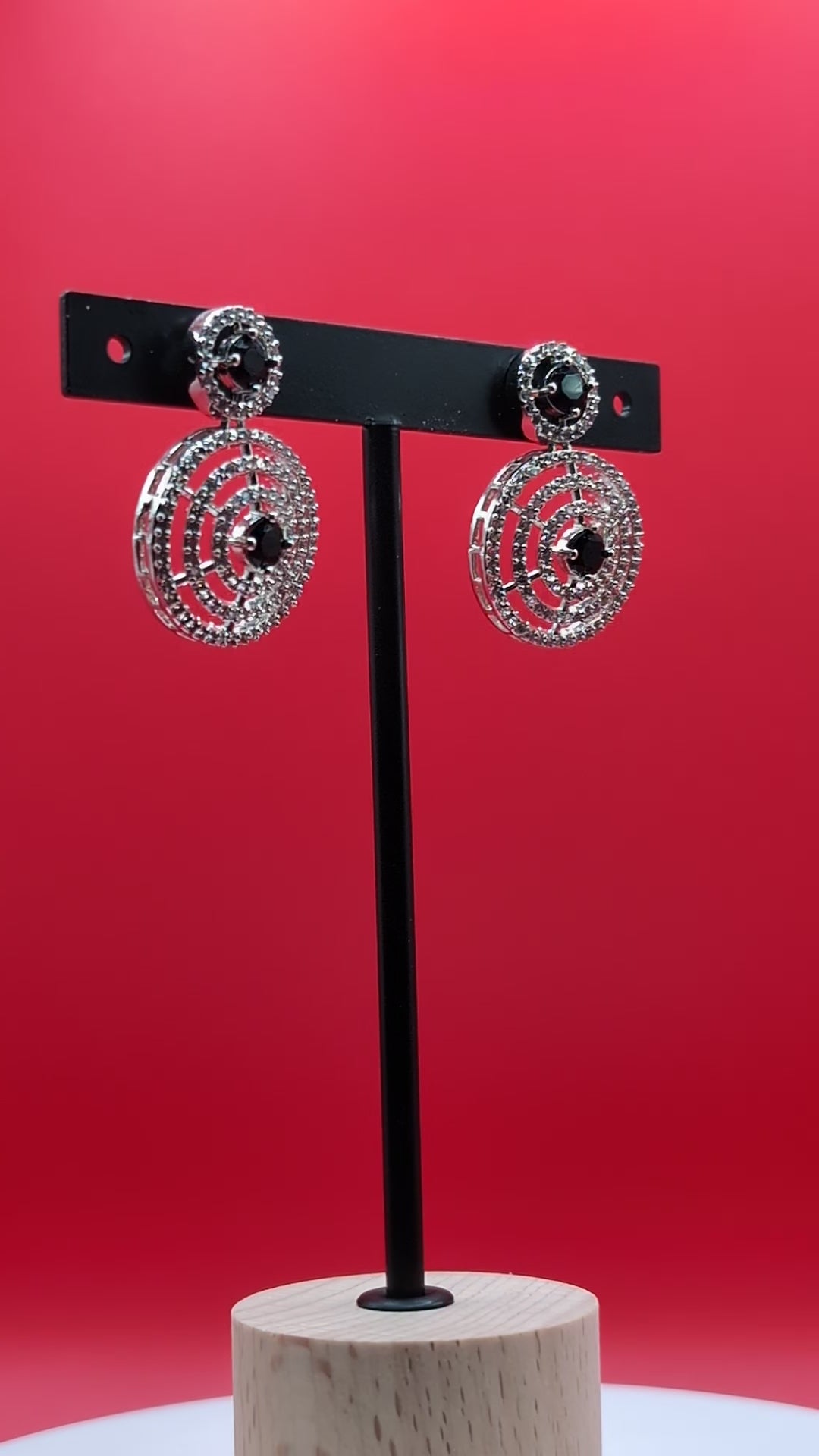 Gold-plated circular drop earrings with sparkling CZ stones and a bold black center stone from The Glisten Collection.