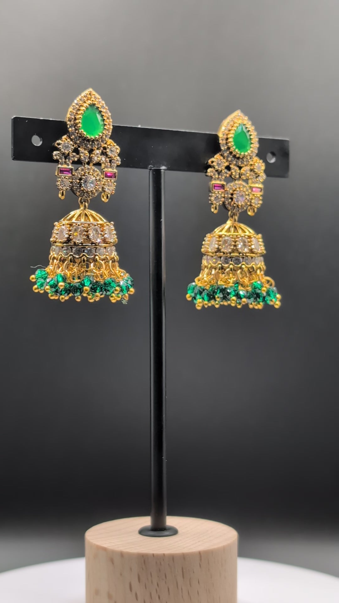 Emerald Flow Jhumkas with green stones, delicate accents, and green bead dangles — perfect for simple yet festive looks at parties and special occasions.
