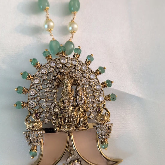 Long green beaded necklace with tiger nail–style pendant and white pearls — statement traditional jewellery ideal for lehengas, sarees, and festive occasions.