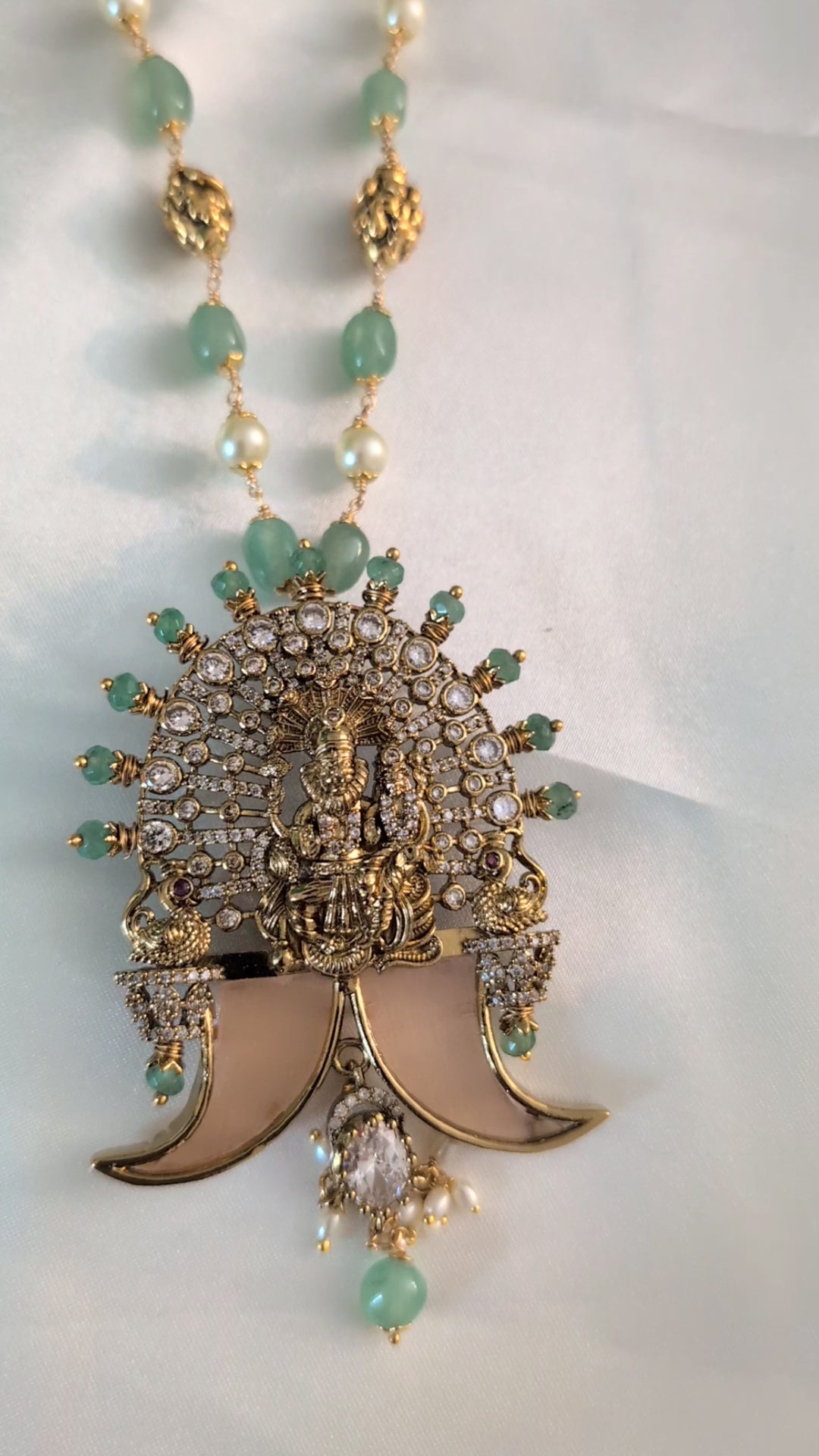 Long green beaded necklace with tiger nail–style pendant and white pearls — statement traditional jewellery ideal for lehengas, sarees, and festive occasions.