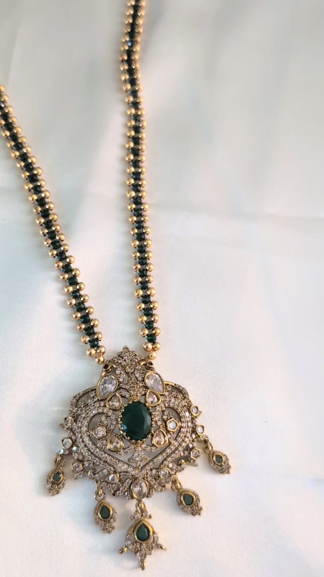 Green color chain necklace with ornate CZ pendant and dangling green stones — elegant festive jewellery for all ages, perfect for weddings and celebrations.